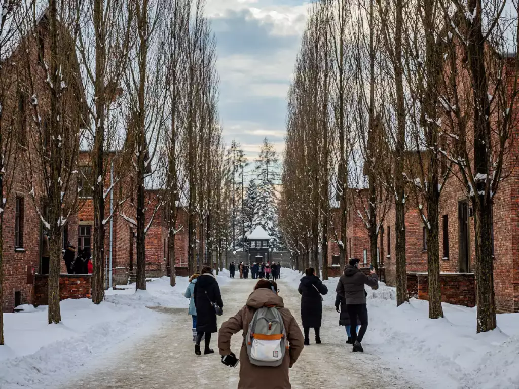 People walking on a path through Auschwitz I in winter