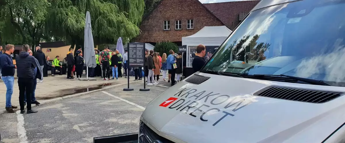 Auschwitz Tour bus parked near the entrance with an Auschwitz guided tour in the background