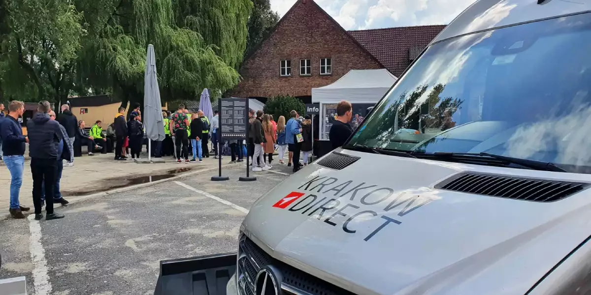 Auschwitz Tour bus parked near the entrance with an Auschwitz guided tour in the background