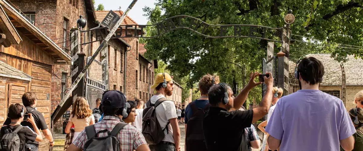 Tourists taking photos of the Auschwitz Gate